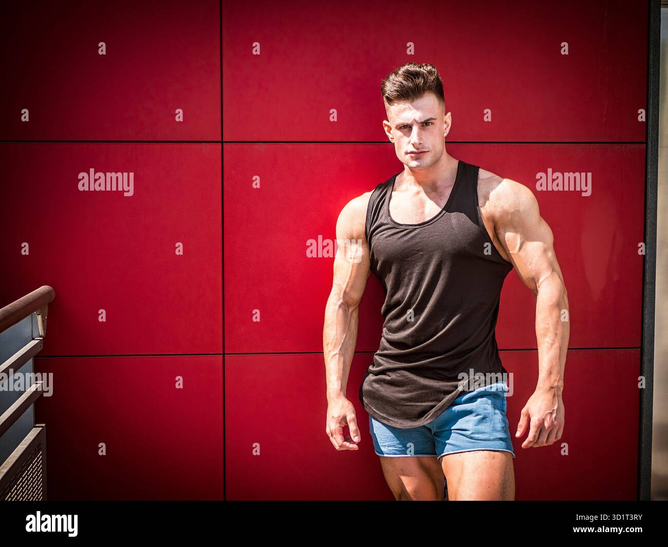 Bel giovane uomo in forma nero canotta-top, all'aperto in città Foto Stock