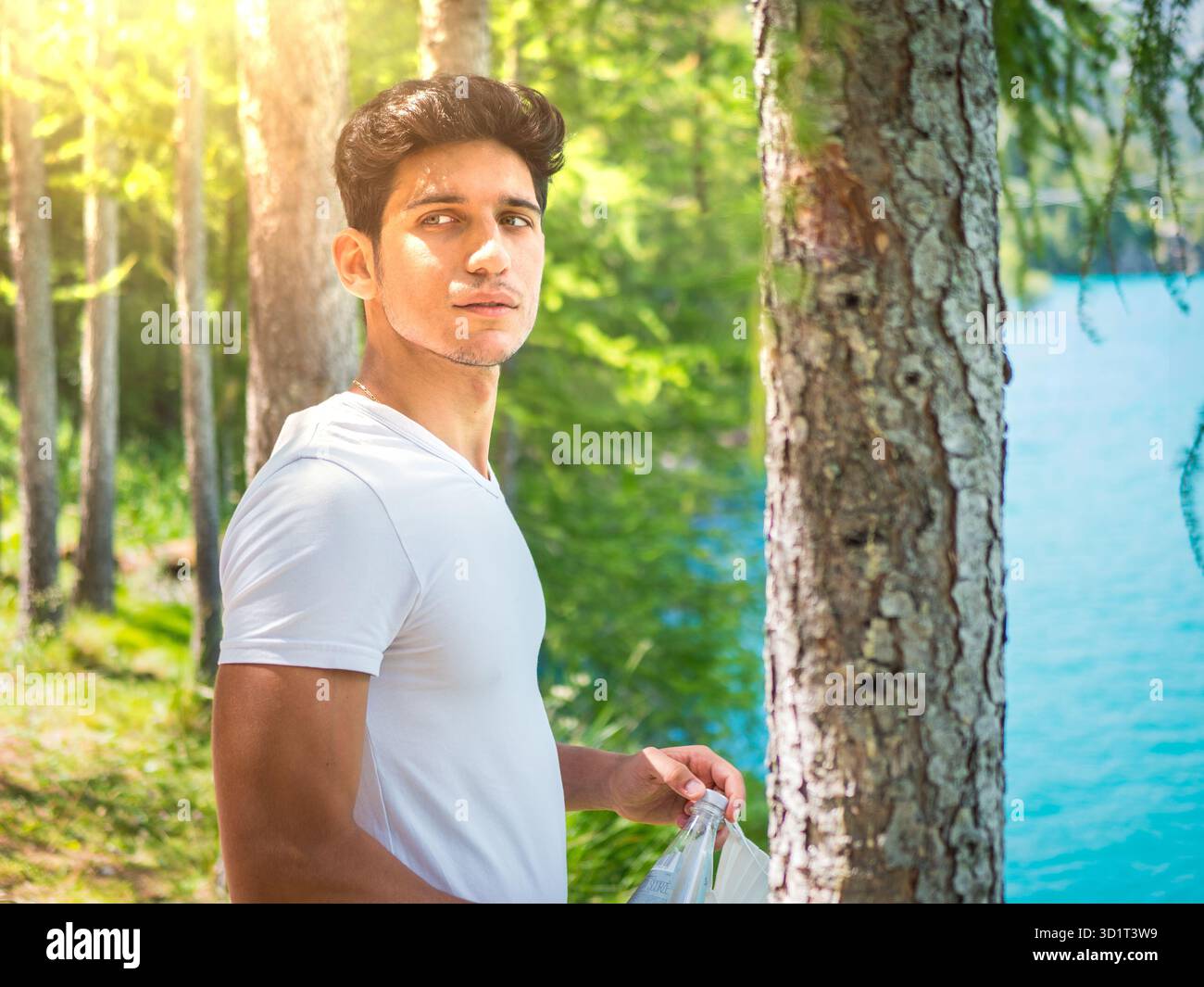 Bell'uomo giovane su un lago in un soleggiato, tranquillo Foto Stock