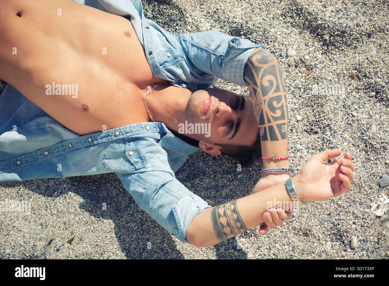 Bell'uomo che si steso sulla tavola da surf in spiaggia Foto Stock