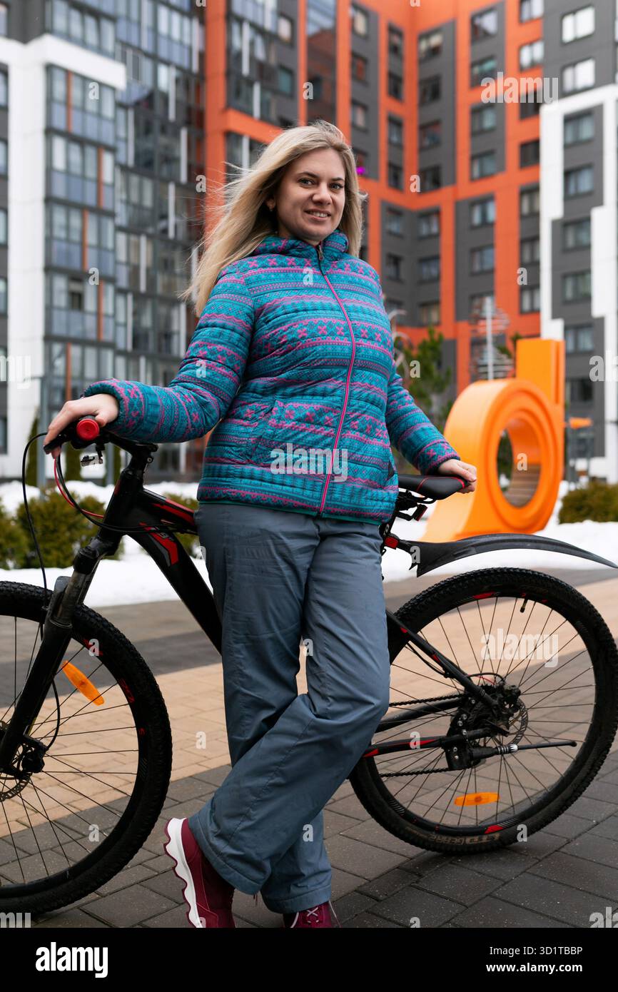 Una donna atletica ama viaggiare in città in bicicletta Foto Stock
