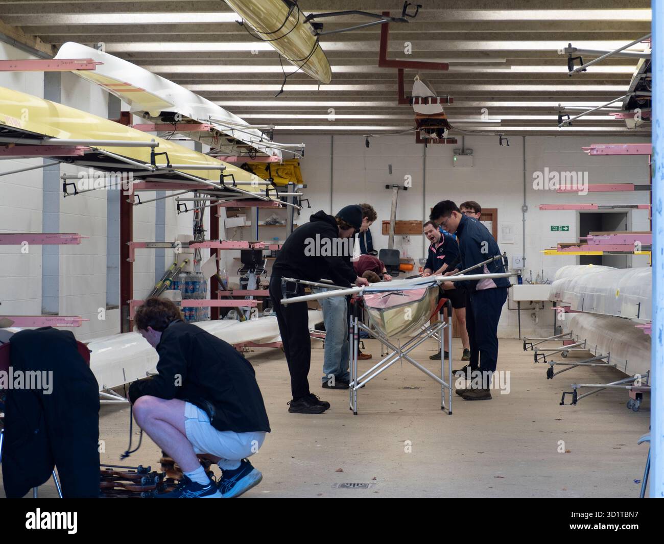 Preparando un teschio per una fila mattutina all'interno di una boathouses universitaria dell'Università di Oxford poco prima dell'alba.queste si trovano convenientemente di fronte al fiume Tamigi, subito a valle del Folly Bridge e del Christ Church Meadows. Foto Stock