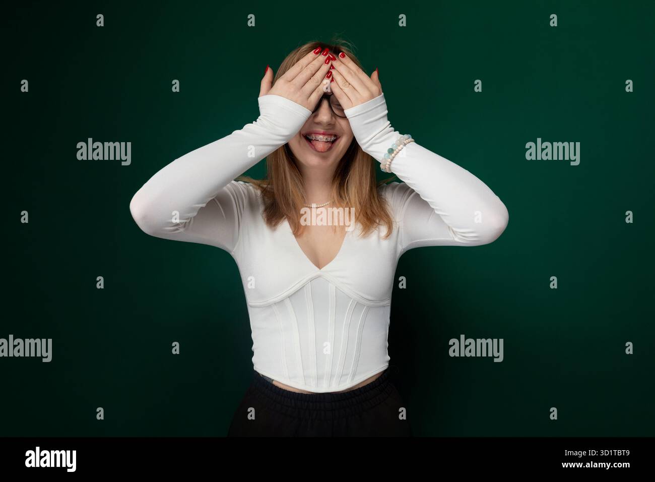 Donna che copre la sua gli occhi con le mani Foto Stock