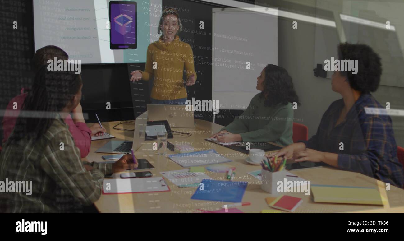 Donna che presenta in cima alla mostarda puntando all'app display nella sala riunioni, con computer portatili e notebook Foto Stock