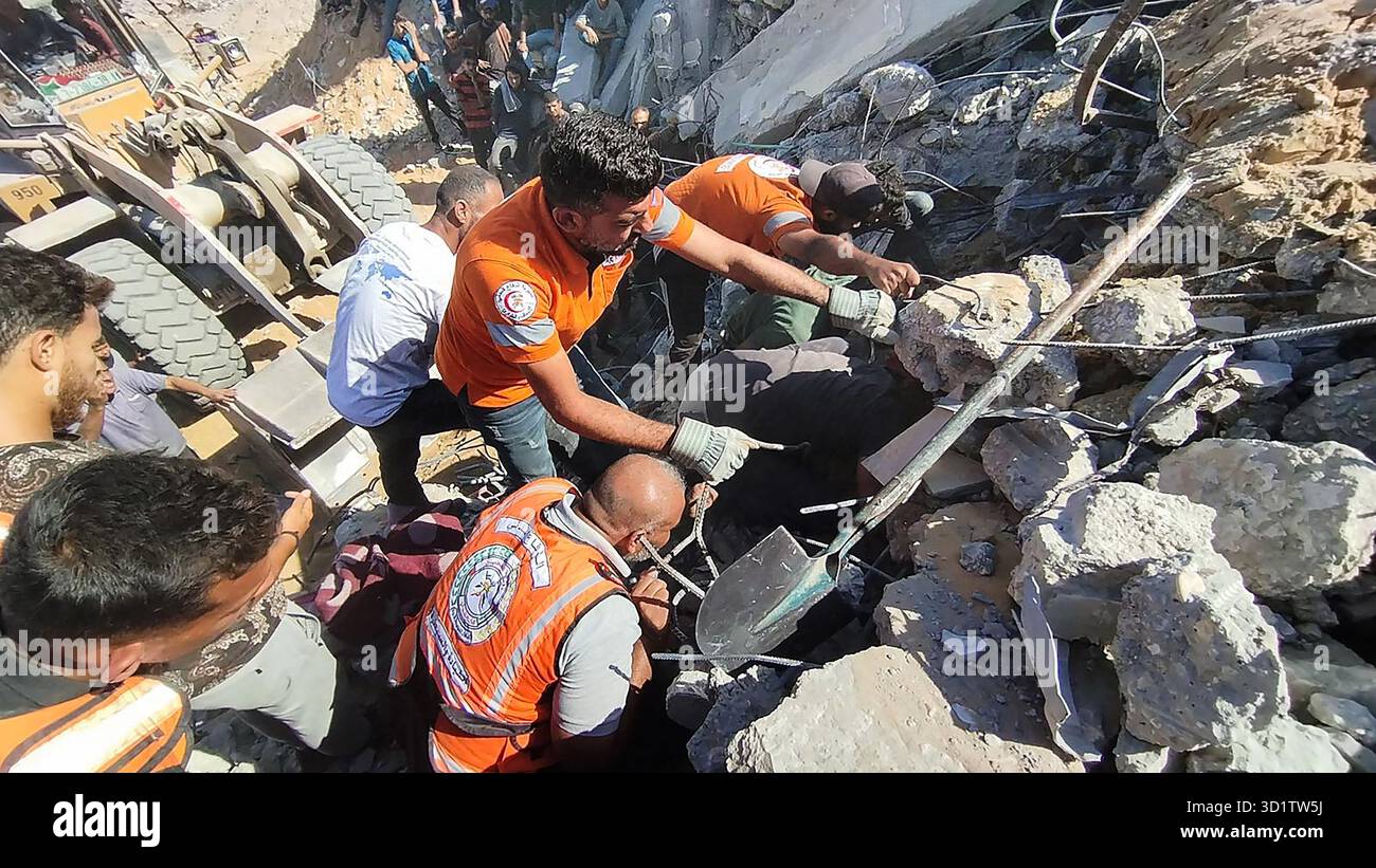 Gaza, Gaza. 29 ottobre 2025. Palestinesi con membri della squadra di difesa civile cercano vittime tra le macerie della casa della famiglia Habib, che è stata colpita in un attacco aereo israeliano nella città centrale di Gaza mercoledì 29 ottobre 2025, in violazione del cessate il fuoco. L'attacco, che ha preso di mira la Striscia di Gaza, ha ucciso almeno 100 persone, tra cui donne e bambini. Foto del servizio stampa della difesa civile palestinese/UPI credito: UPI/Alamy Live News Foto Stock