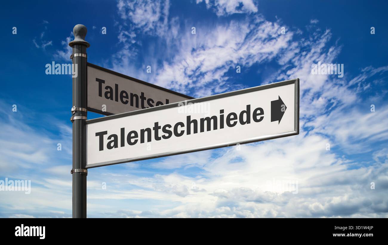 Un'immagine con un cartello in tedesco che punta in direzione della fabbrica di talenti. Foto Stock