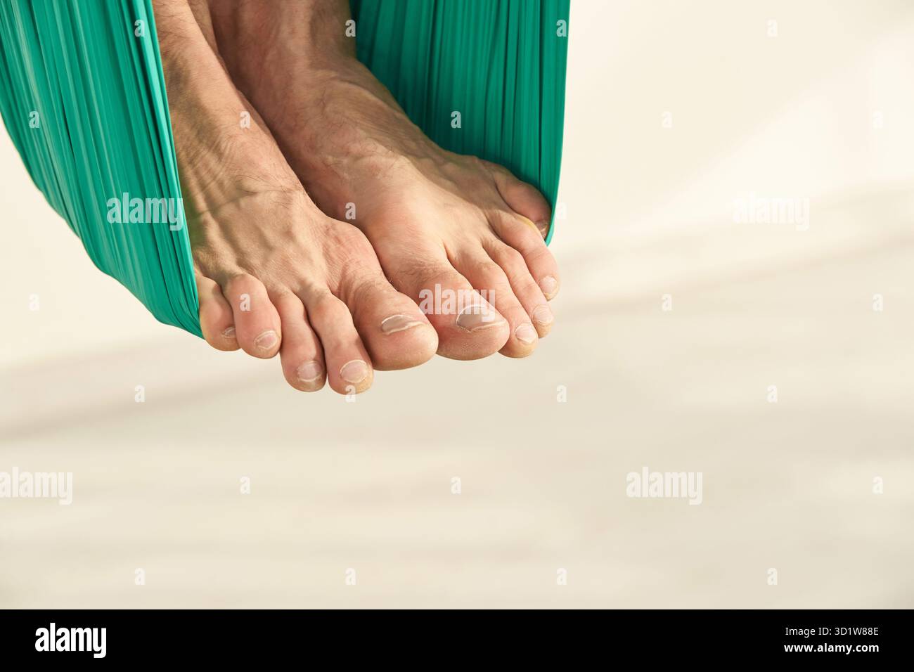 Persona maschile fare amaca yoga lezione di esercizio. Meditazione in aria calma Foto Stock