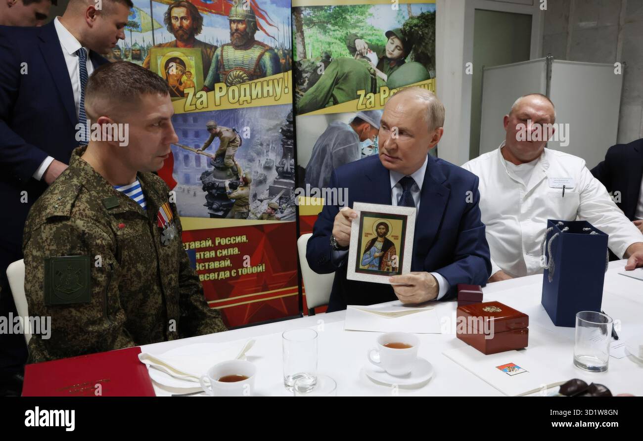 Mosca, Russia. 29 ottobre 2025. Il presidente russo Vladimir Putin, centro, detiene l'icona di St. Alexander Nevsky mentre parla ai soldati con la 127a brigata di ricognizione separata durante il pranzo presso il Mandryk Central Military Clinical Hospital, il 29 ottobre 2025 a Mosca, Russia. Crediti: Vyacheslav Prokofyev/piscina del Cremlino/Alamy Live News Foto Stock