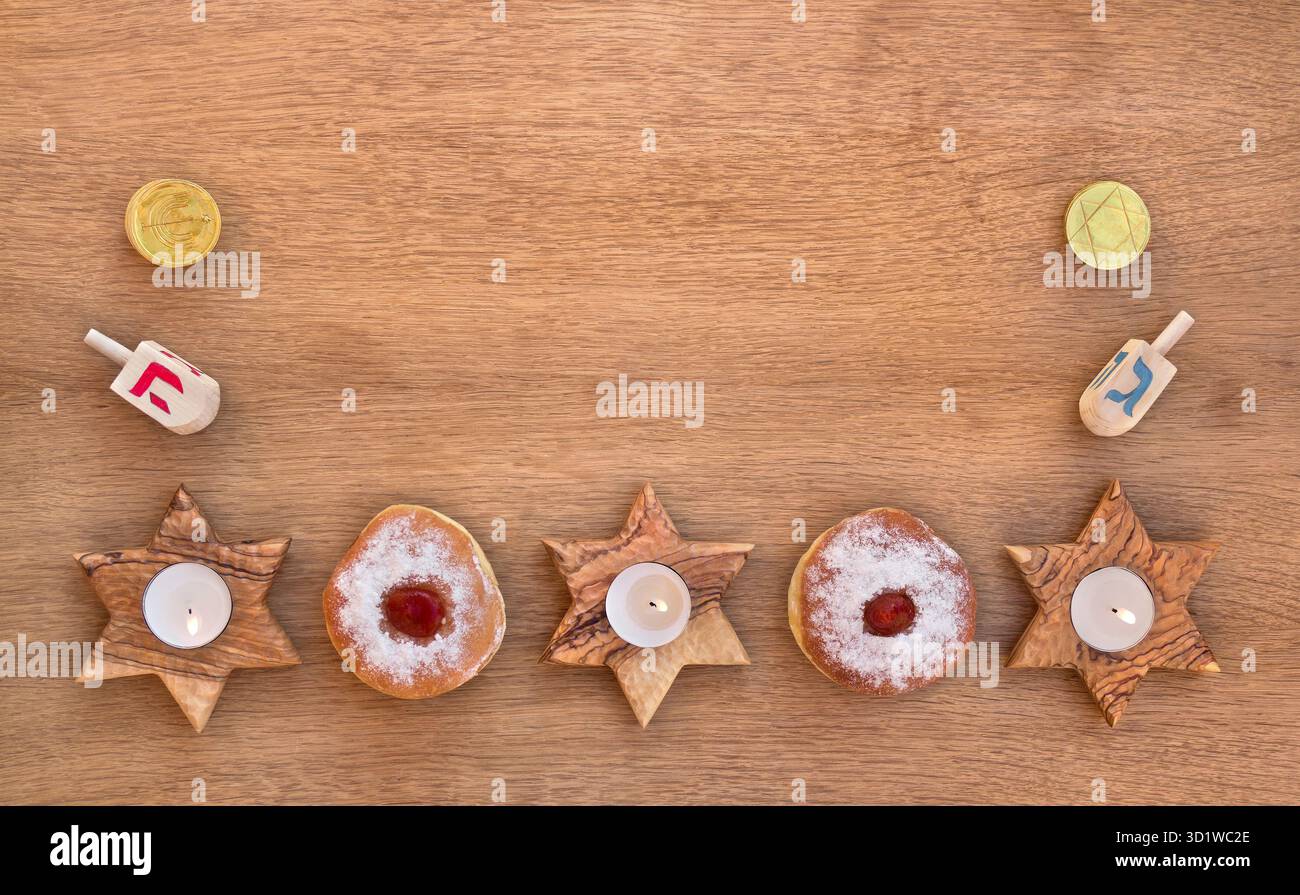 Candelabri di legno a forma di stella, ciambella e ciambelle sullo sfondo di tavole di legno con spazio per il testo. Festa ebraica Hanukkah. Vista dall'alto Foto Stock