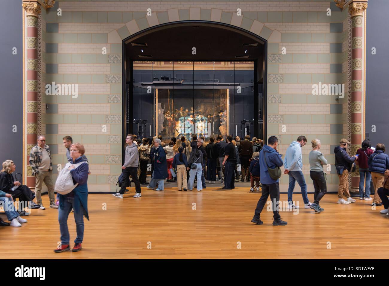 I visitatori camminano attraverso la Galleria d'Onore nel Rijksmuseum verso l'iconico dipinto la Guardia di notte, esposto in modo prominente nell'arco centrale Foto Stock