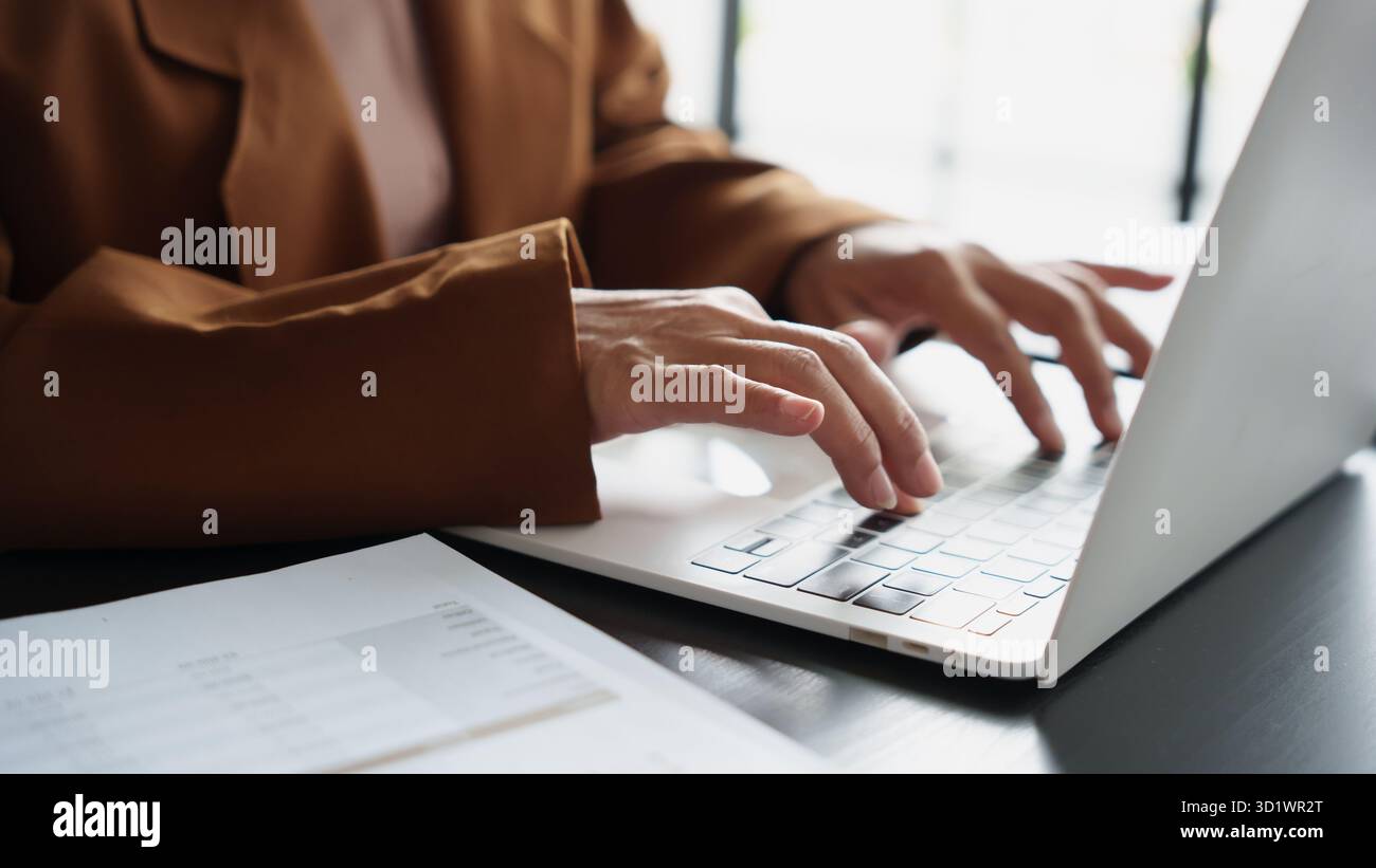 Maturo business asiatico donna imprenditrice in ufficio che utilizza laptop. donna d'affari degli anni '60 con donna anziana asiatica di tecnologia Foto Stock