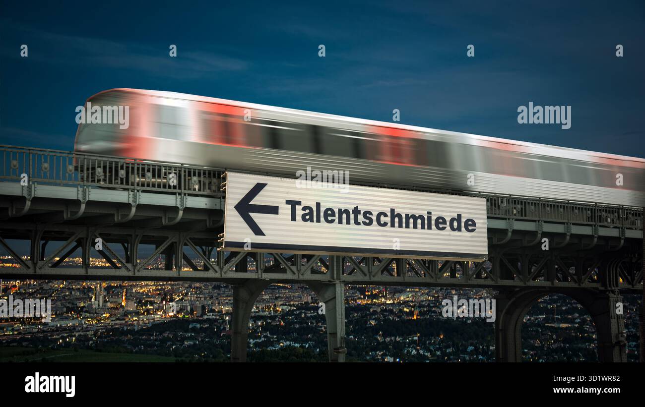 Un'immagine con un cartello in tedesco che punta in direzione della fabbrica di talenti. Foto Stock