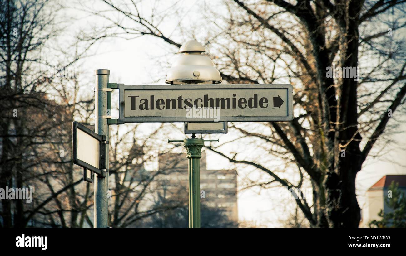 Un'immagine con un cartello in tedesco che punta in direzione della fabbrica di talenti. Foto Stock