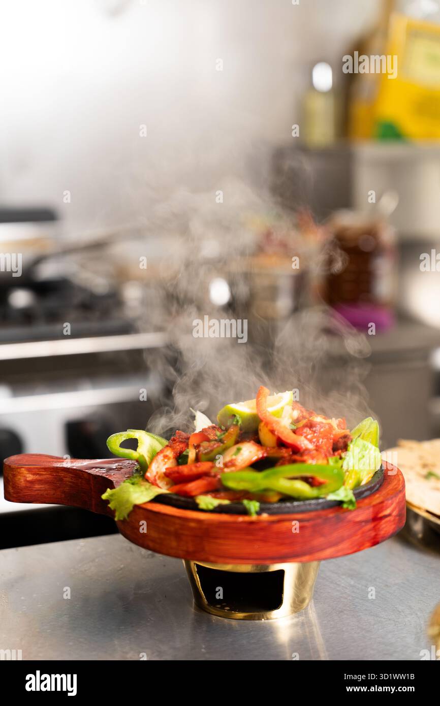 Cottura a vapore di Fajitas caldi su piastra sfrigolante Foto Stock