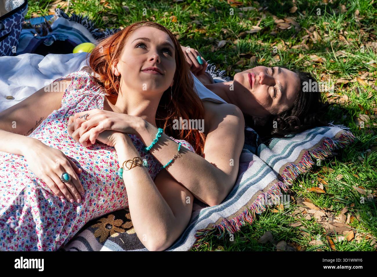 Momenti radiosi: Due donne abbracciano l'amicizia e la gioia in un picnic primaverile in fiore Foto Stock