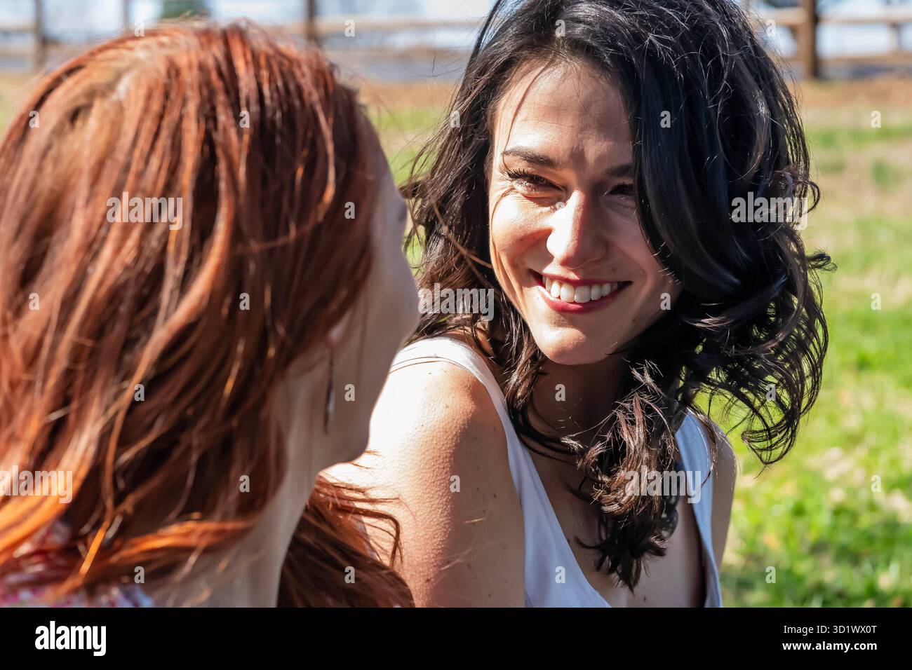 Momenti radiosi: Due donne abbracciano l'amicizia e la gioia in un picnic primaverile in fiore Foto Stock