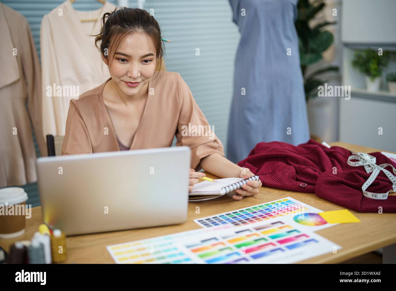 Donna sartoriale che lavora in sartoria elegante stilista sartoriale in studio di officina che disegna la nuova collezione Dressmaking e. Foto Stock