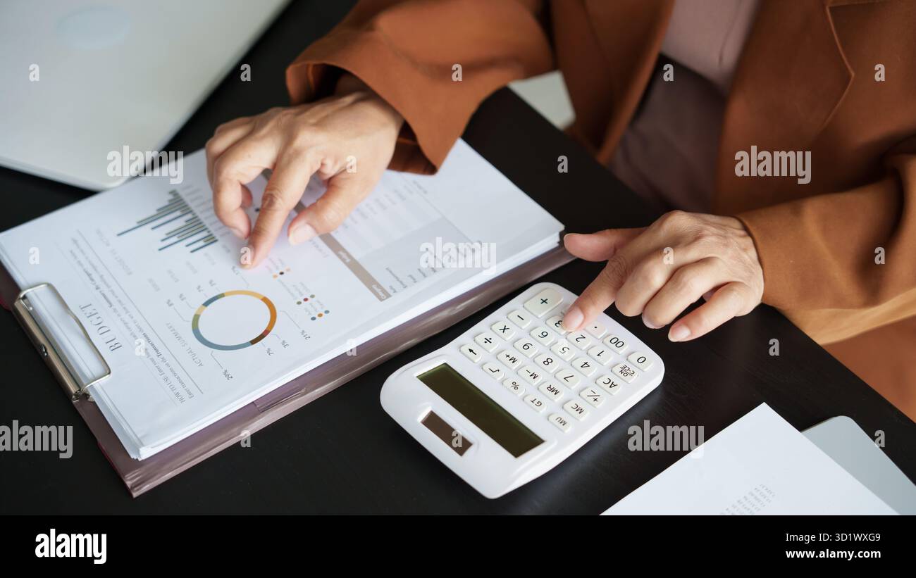 Donna asiatica di mezza età revisore dei conti o personale del servizio delle entrate interno donna d'affari anziana anziana che controlla annuale finanziaria donna p Foto Stock