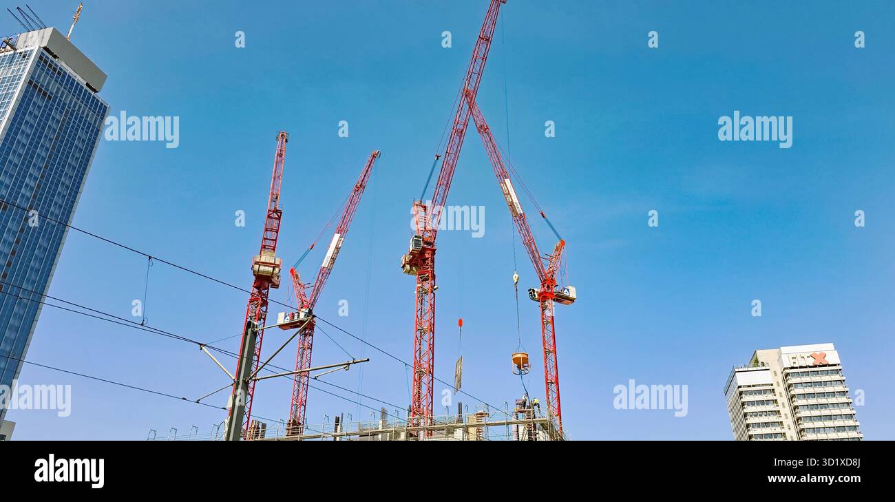 Berlino, Germania - 13 giugno 2025: Le gru da costruzione dominano lo skyline urbano, mostrando architettura e ingegneria moderne. - Immagine stock catturata con smartphone