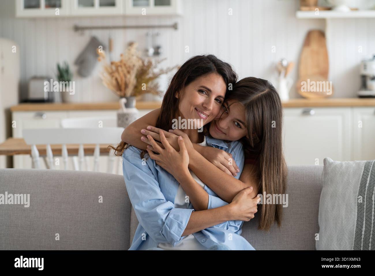 Una famiglia di donne e adolescenti che abbracciano la vita si siede nel salotto del divano dell'appartamento Foto Stock