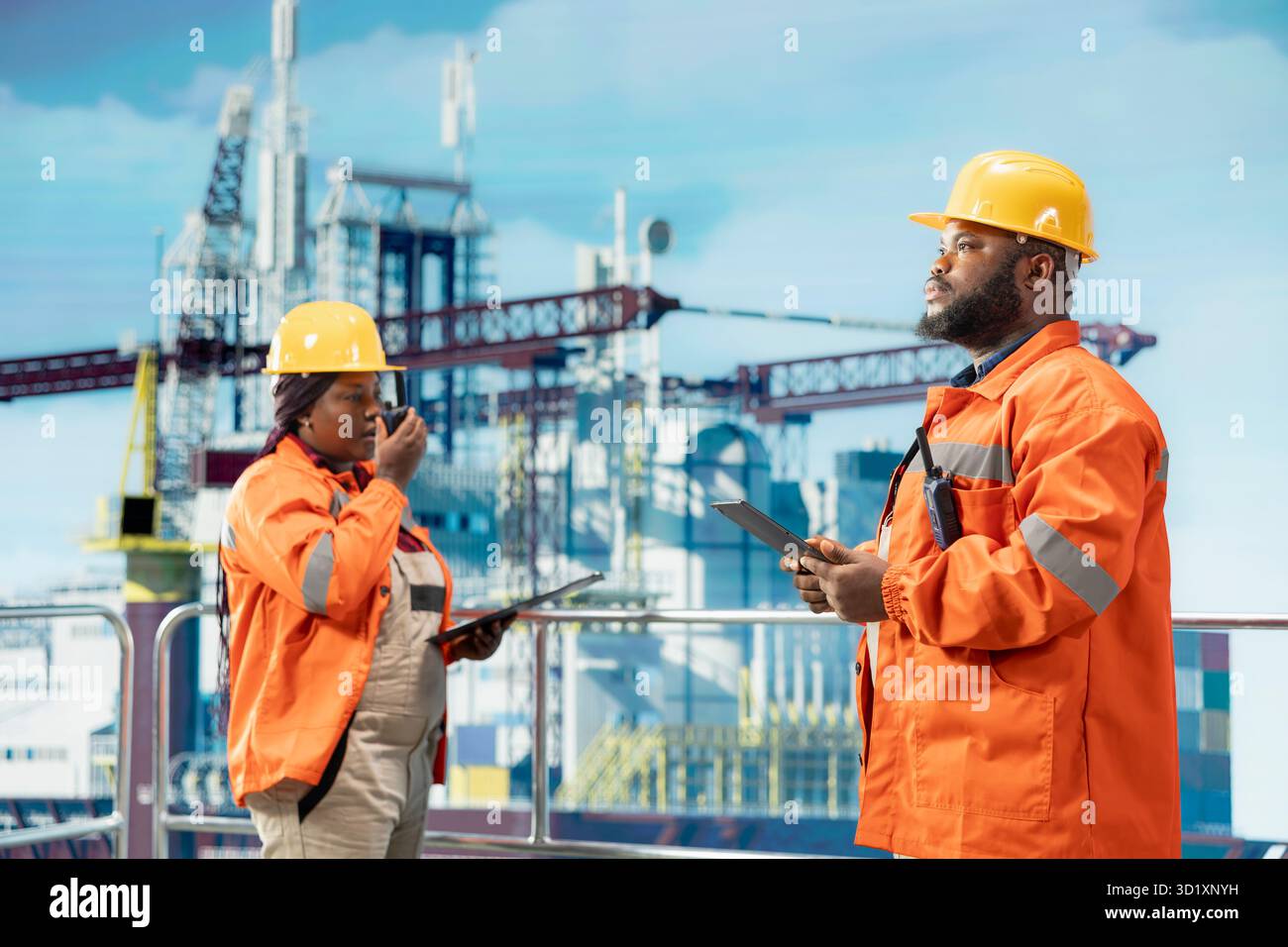 I colleghi della piattaforma offshore supervisionano le operazioni del deck con i tablet, garantendo la conformità ai protocolli di sicurezza. Team di tecnici che lavorano insieme per la manutenzione preventiva del carro di perforazione Foto Stock