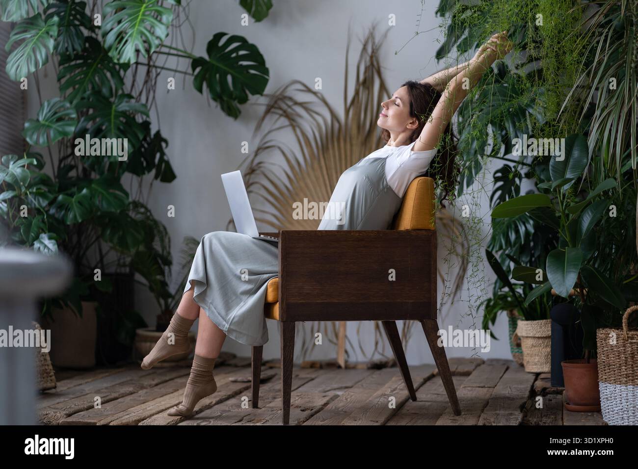Calma italiana donna freelance giardiniere con occhi chiusi rilassarsi mentre al suo giardino accogliente casa Foto Stock