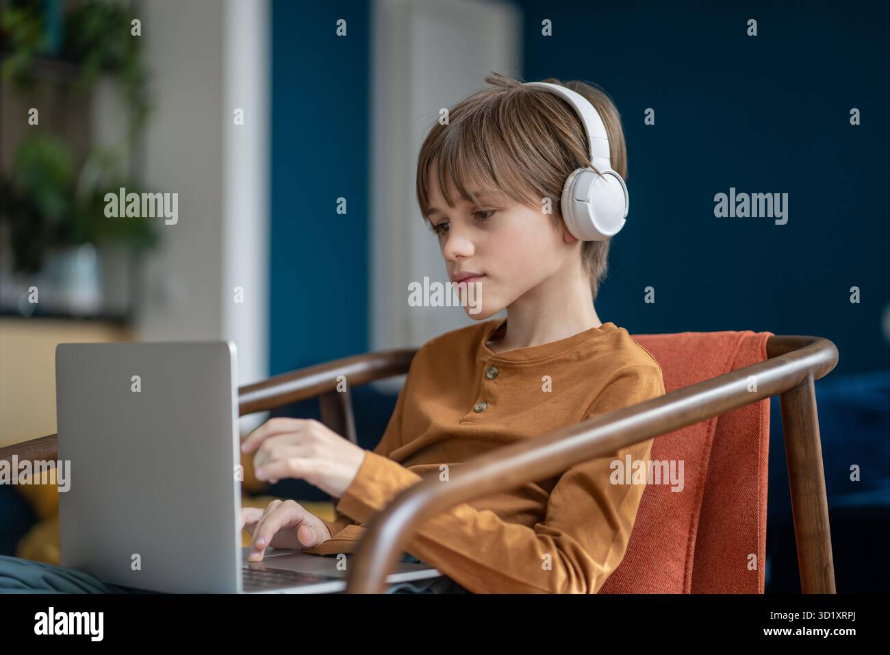 Ragazzo serio e attento in cuffie con classe online didattica sul notebook. Foto Stock