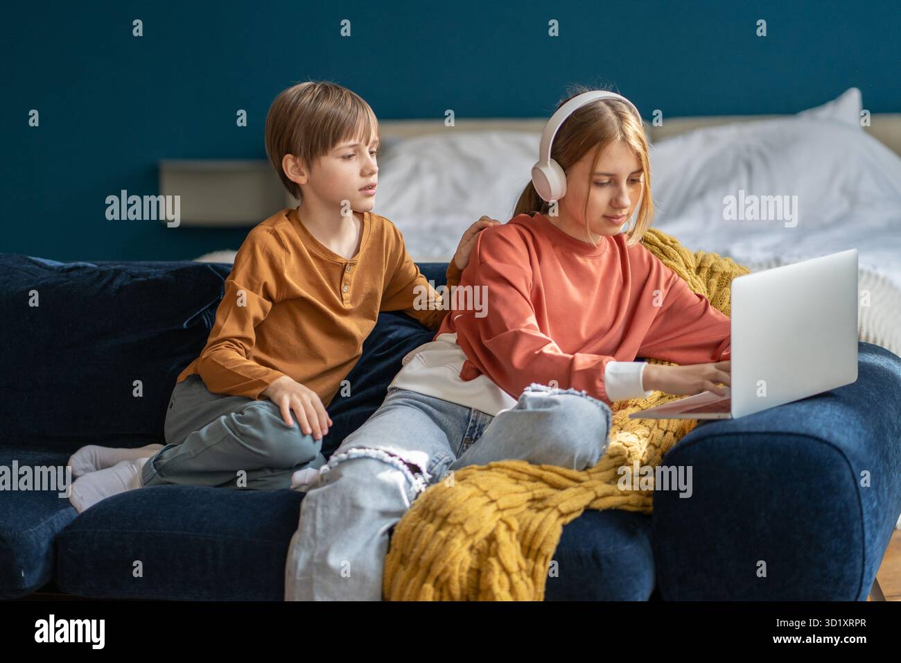 Bambini, fratello e sorella seduti insieme al computer portatile sul divano Foto Stock