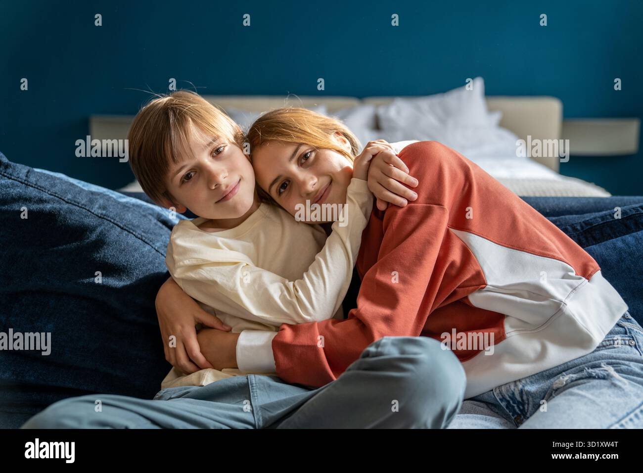 Fratelli felici che abbraccia l'amore e la connessione della sensibilità cocdling. Ragazzo sorridente che abbraccia la sorella maggiore Foto Stock