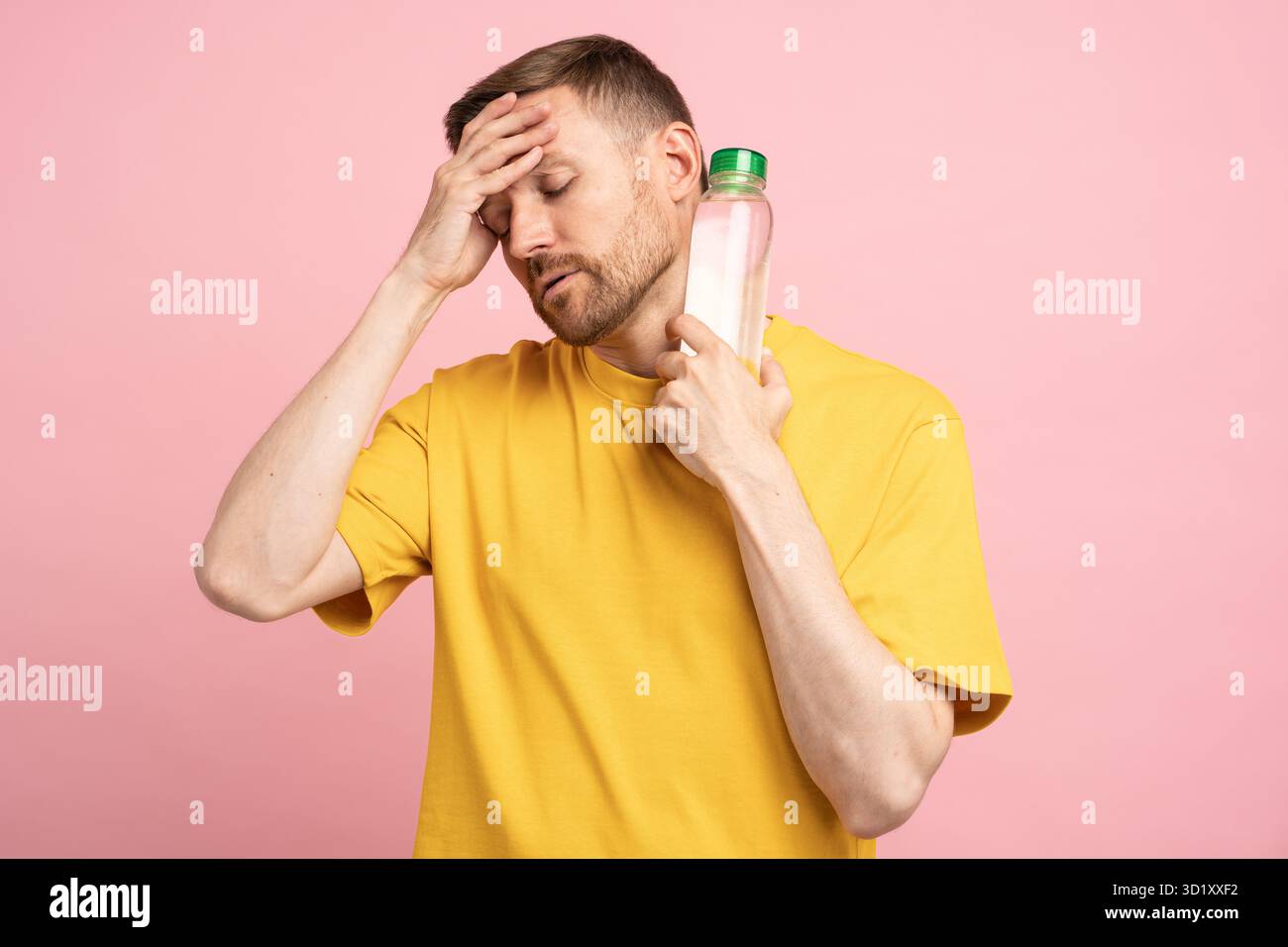 L'uomo stanco soffre di calore e pressione sanguigna, mette bottiglia di acqua fredda al collo, si sente disidratato. Foto Stock