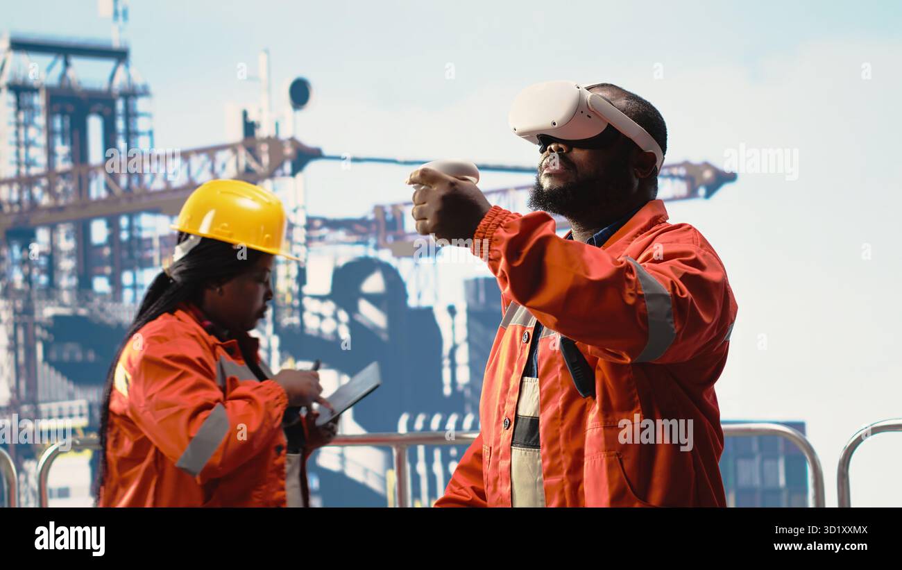 Operaio di piattaforme di perforazione offshore che supervisiona le operazioni di coperta utilizzando la simulazione della realtà virtuale, garantendo la conformità ai protocolli di sicurezza. Il tecnico esegue il controllo del carro di perforazione con gli occhiali VR Foto Stock