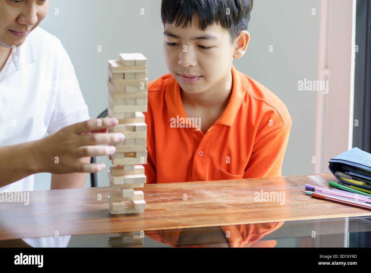 Padre e figlio asiatici che giocano a blocchi di legno bambino Carefree che gioca a blocchi di legno costruttore di costruzioni di blocchi di legno da blocchi con padre Foto Stock
