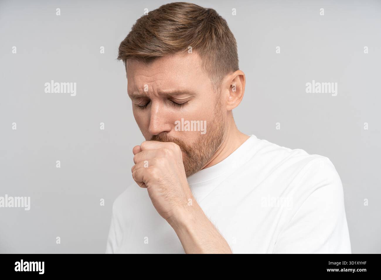L'uomo malato con sintomi influenzali sente il disagio tosse a causa di malattia isolato su sfondo grigio studio Foto Stock