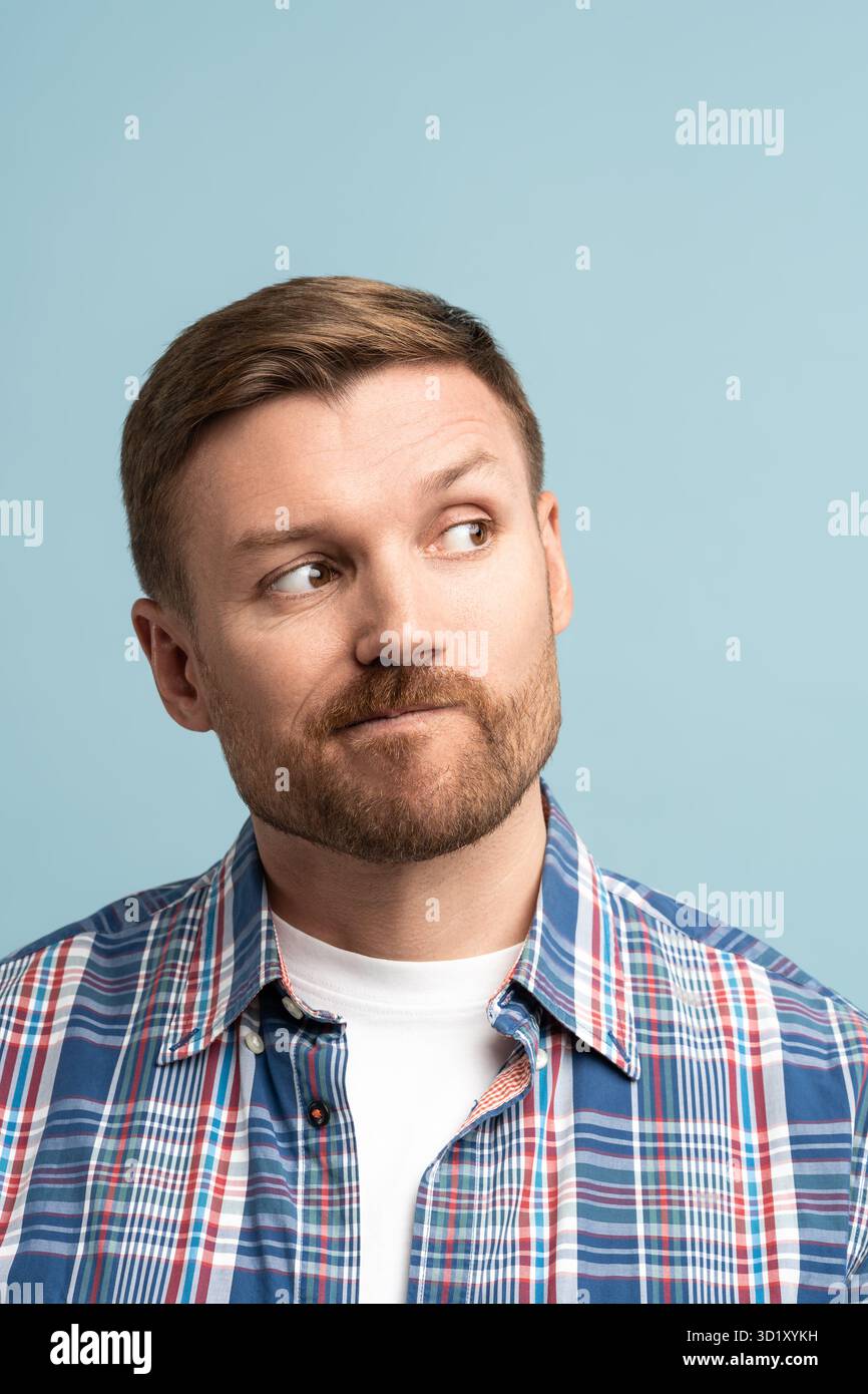 L'uomo di mezza età che cerca le labbra guarda nell'angolo in alto a destra, fa la scelta, sullo spazio di copia. Foto Stock