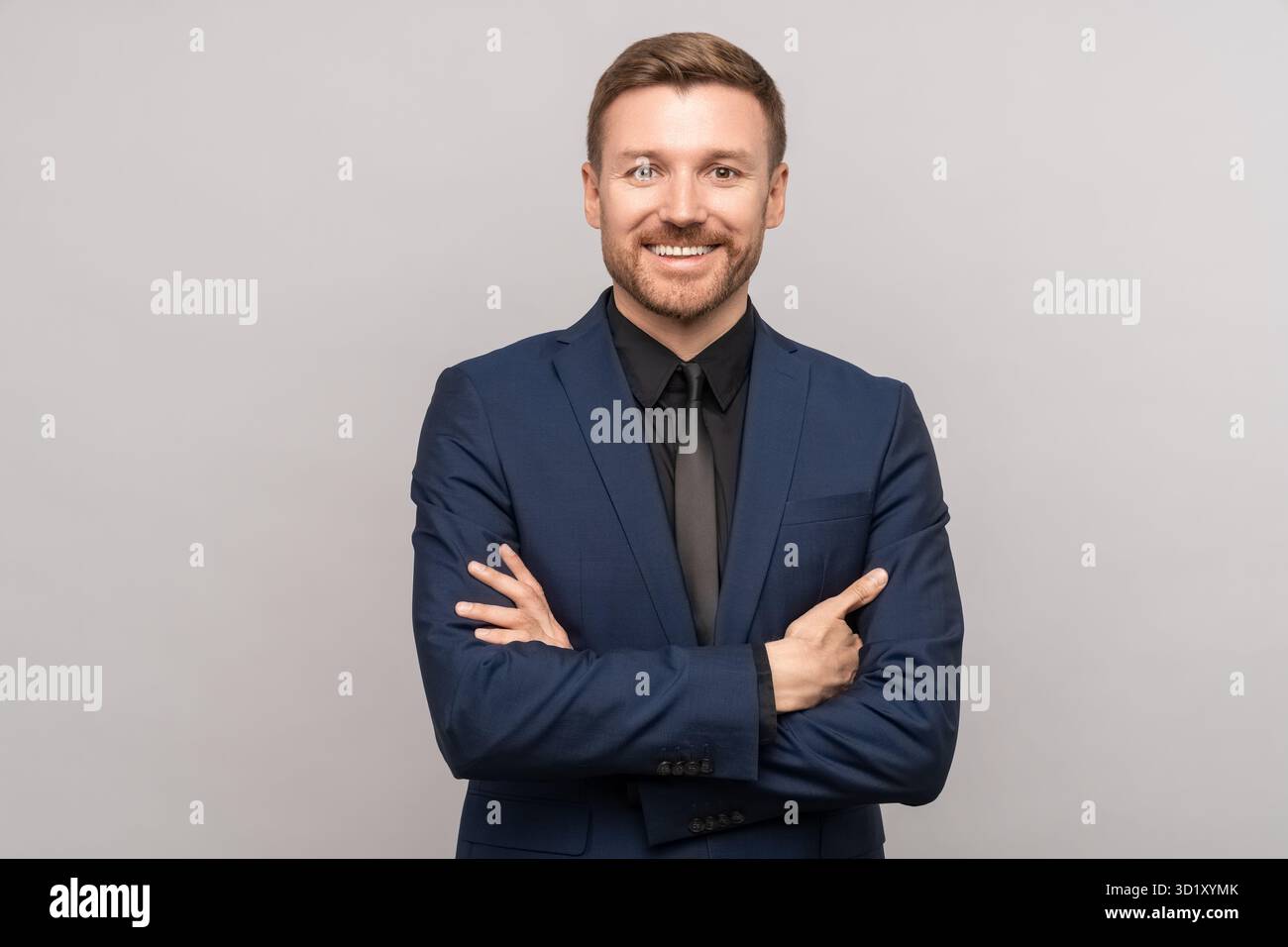 Il commerciante di successo ha incrociato le braccia, sorridendo. Manager Director dipendente ritratto, isolato in grigio Foto Stock