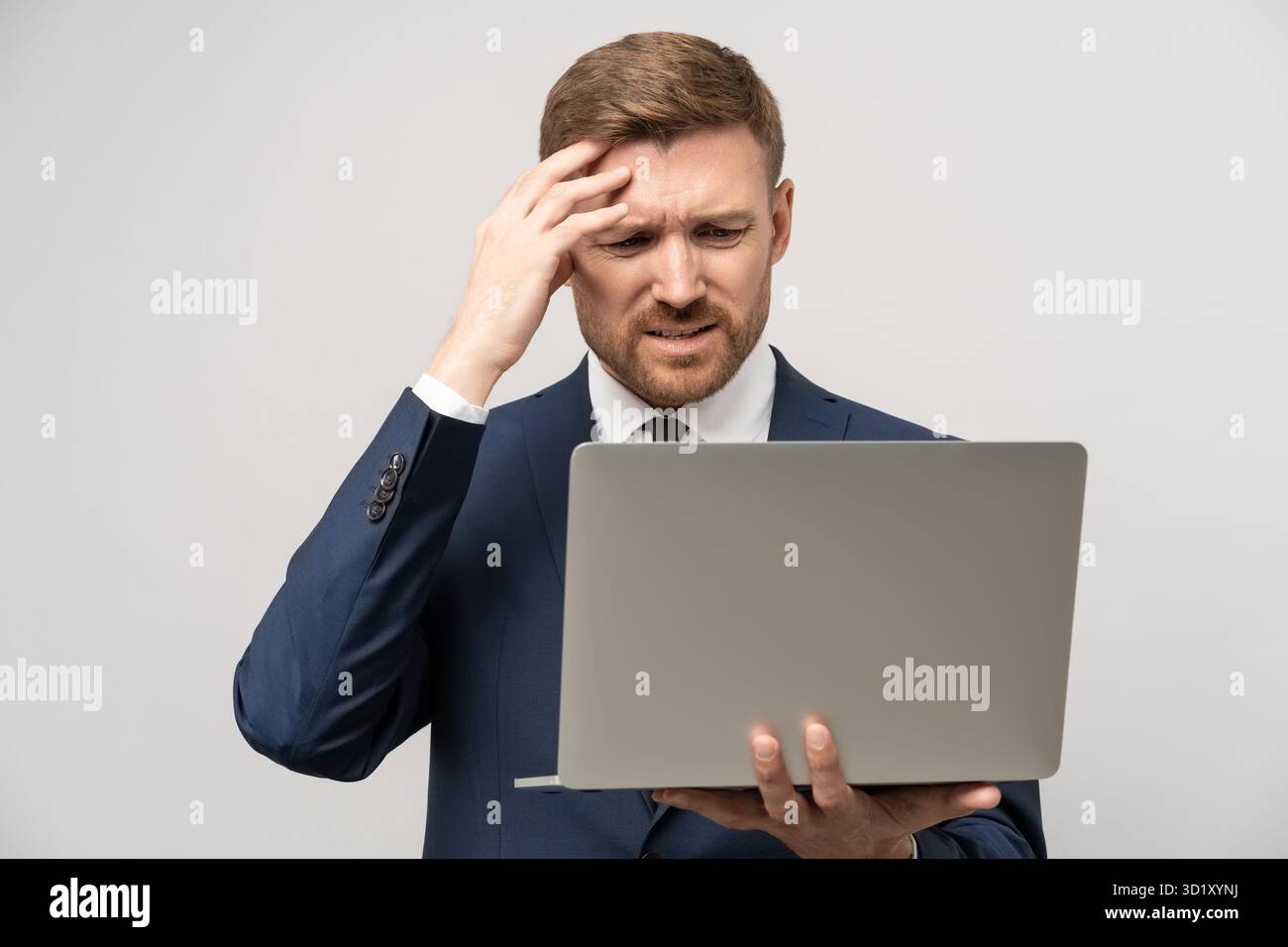 Un uomo d'affari frustrato, sotto stress emotivo, ha visto il crollo del mercato azionario sui notebook, ha perso denaro a causa della caduta dei prezzi azionari. Furioso commerciante in costume Foto Stock