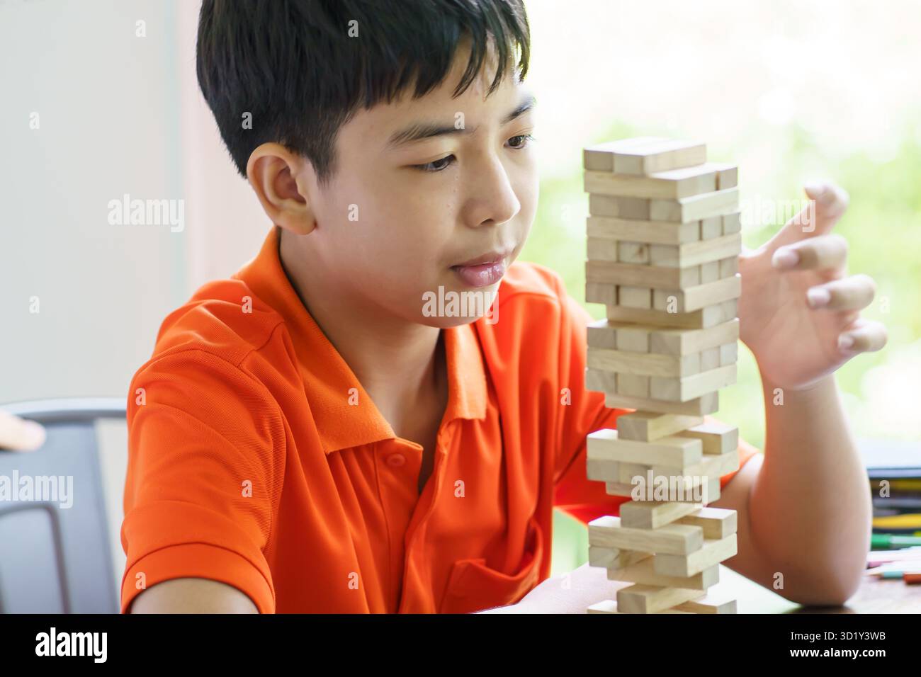 Padre e figlio asiatici che giocano a blocchi di legno bambino Carefree che gioca a blocchi di legno costruttore di costruzioni di blocchi di legno da blocchi con padre Foto Stock