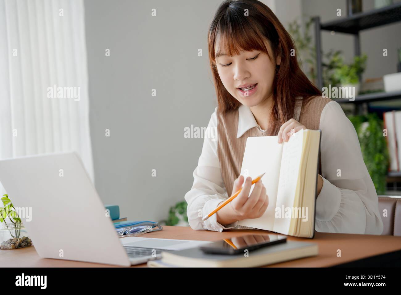 Donna asiatica che usa il laptop per studiare studentessa impegnata nell'apprendimento online all'università Foto Stock