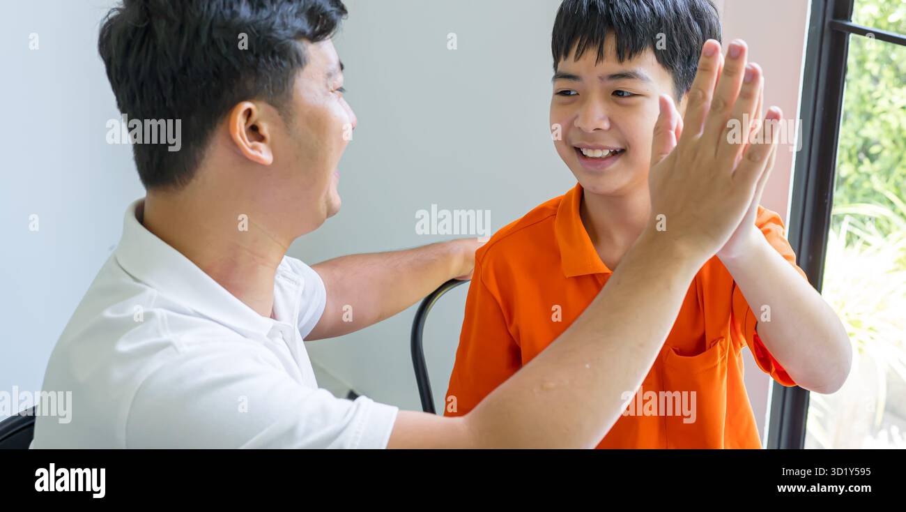 Padre e figlio asiatici che danno un buon cinque padre che passa il tempo libero con il bambino celebrando il successo dei bambini relazione famiglia Foto Stock