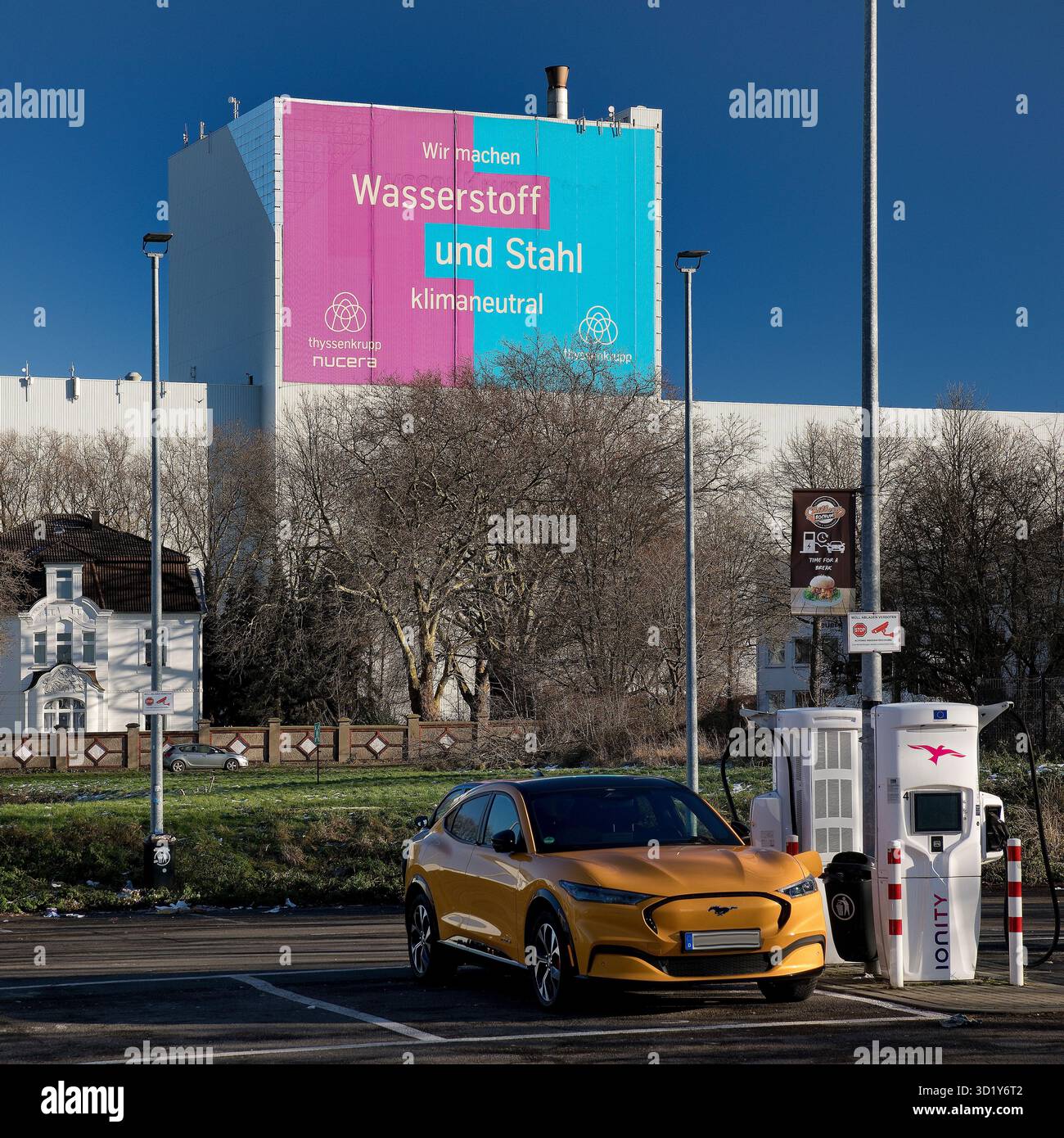 Stazione di ricarica elettronica e grande poster per l'acciaio per climi presso lo stabilimento ThyssenKrupp Steel Europe di Bochum Foto Stock