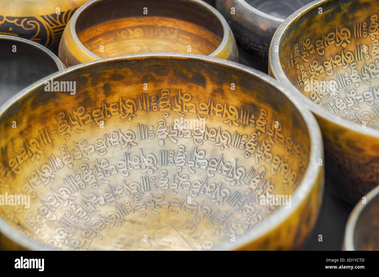 Le dettagliate iscrizioni sanscrite decorano queste ciotole tibetane in ottone, utilizzate nei rituali di meditazione e relax Foto Stock