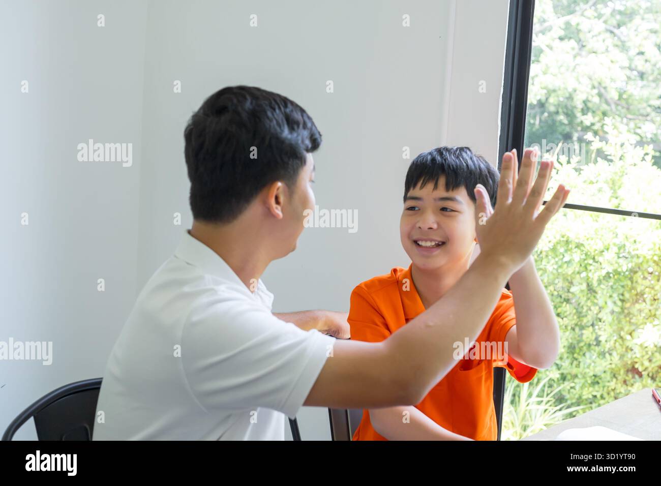 Padre e figlio asiatici che danno un buon cinque padre che passa il tempo libero con il bambino celebrando il successo dei bambini relazione famiglia Foto Stock