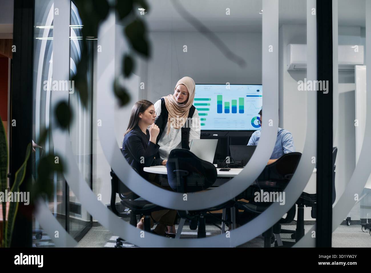 Un gruppo eterogeneo di uomini d'affari collabora e testa una nuova tecnologia di realtà virtuale, indossando occhiali virtuali, mostrando inno Foto Stock