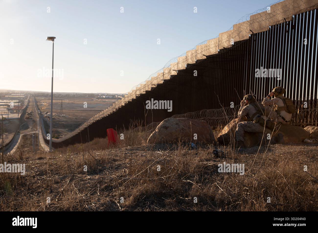 Frank Lopez, a sinistra, e George Hollerman, entrambi assistenti di pattuglia, con il 3rd Battalion, 4th Marine Regiment, 1st Marine Division, assegnati alla Joint Task Force-Southern Border (JTF-SB), monitorano la barriera del confine meridionale durante una pattuglia nei pressi di San Ysidro, California, 18 ottobre 2025. JTF-SB esegue operazioni su larga scala, agili e su tutti i domini a sostegno della protezione delle dogane e delle frontiere degli Stati Uniti per proteggere l'integrità territoriale degli Stati Uniti e ottenere il controllo operativo al 100% del confine meridionale. (Foto del corpo dei Marines degli Stati Uniti di Lance Cpl. Diego Berume Foto Stock