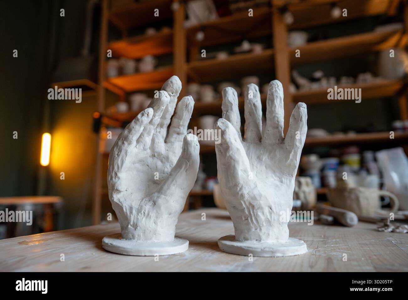 Scultura di argilla a due mani su tavolo in studio di ceramica, abile arte artistica e fantasiosa arte di design Foto Stock