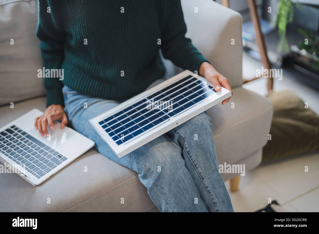 Donna asiatica che impara a conoscere le energie rinnovabili il controllo remoto dell'energia solare nella sua casa e l'installazione di pannelli solari sostenibili technolo Foto Stock