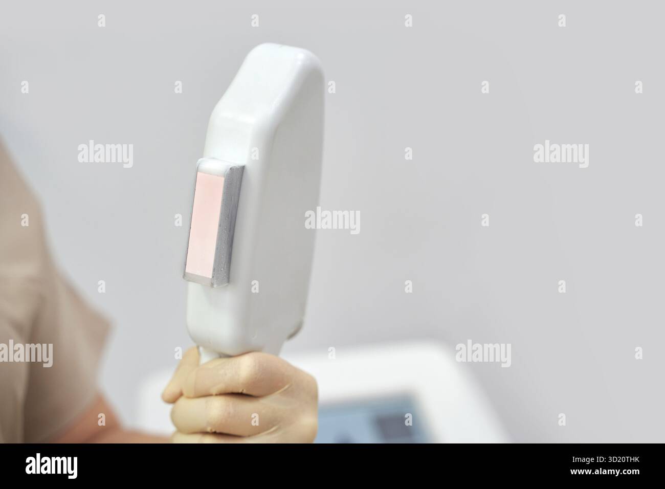 Primo piano del dispositivo di rimozione dei peli del laser di tenuta della mano in ambiente medico Foto Stock