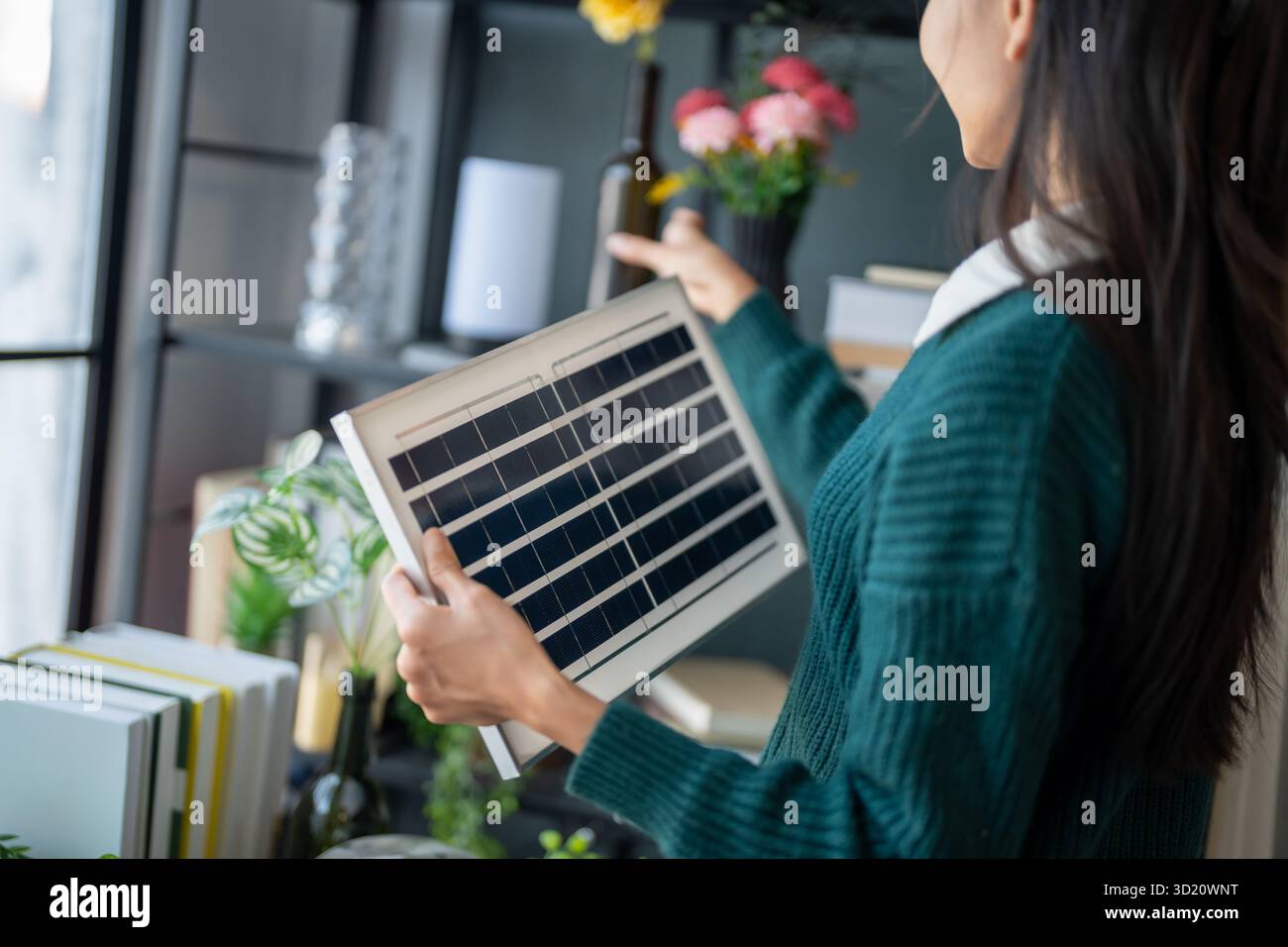 Il proprietario di casa installa sistemi di energia solare nella sua casa donna asiatica che impara a conoscere la tecnologia sostenibile Foto Stock
