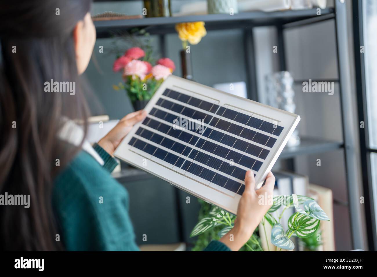 Il proprietario di casa installa sistemi di energia solare nella sua casa donna asiatica che impara a conoscere la tecnologia sostenibile Foto Stock