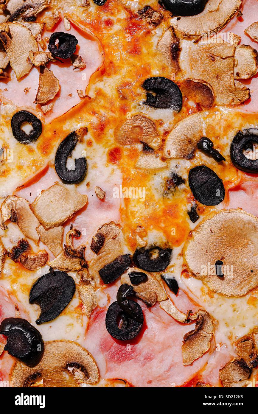 La pizza condita con funghi e olive nere offre una deliziosa combinazione di sapori e consistenze Foto Stock