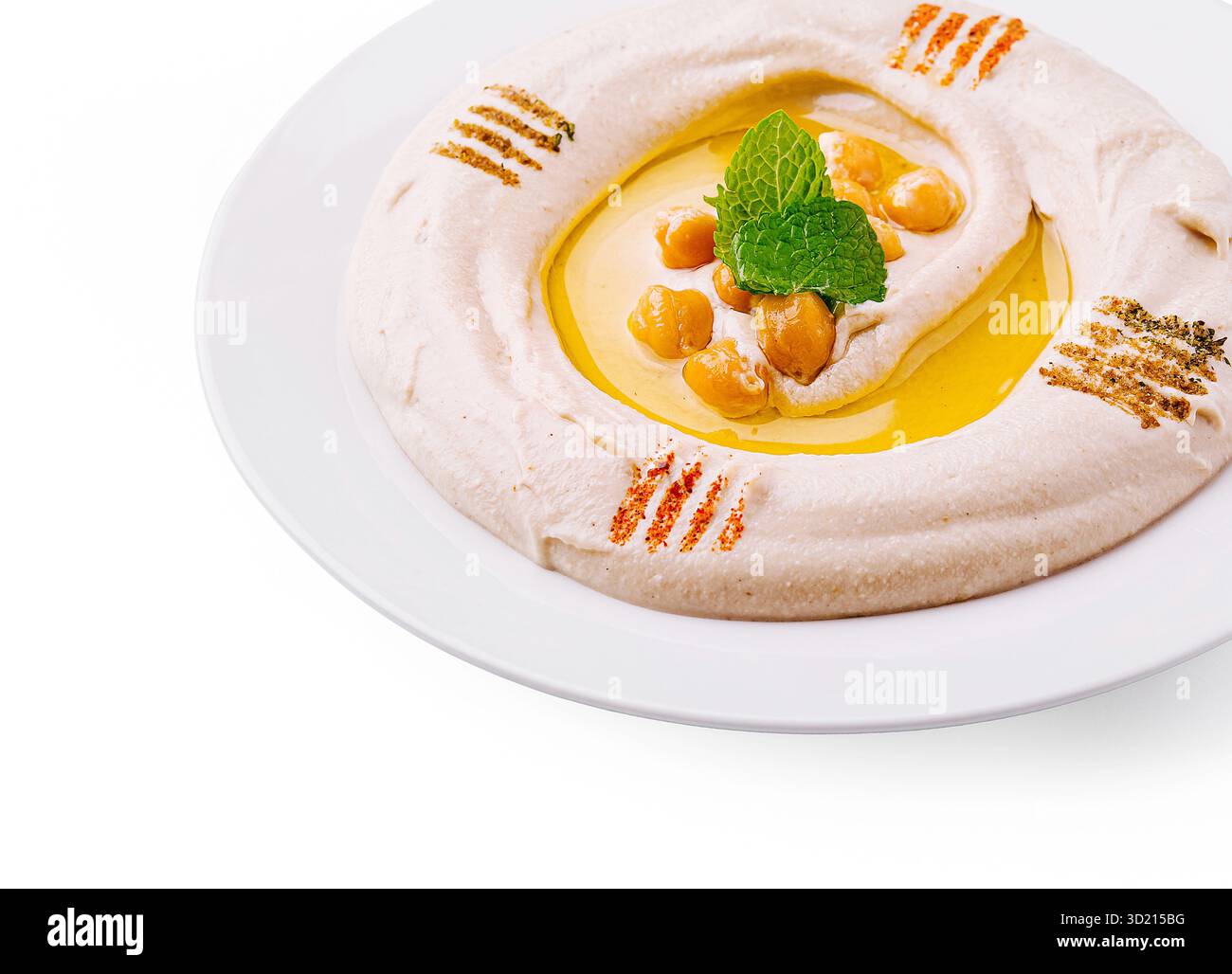 Hummus cremoso servito su un piatto bianco guarnito con ceci e olio d'oliva Foto Stock
